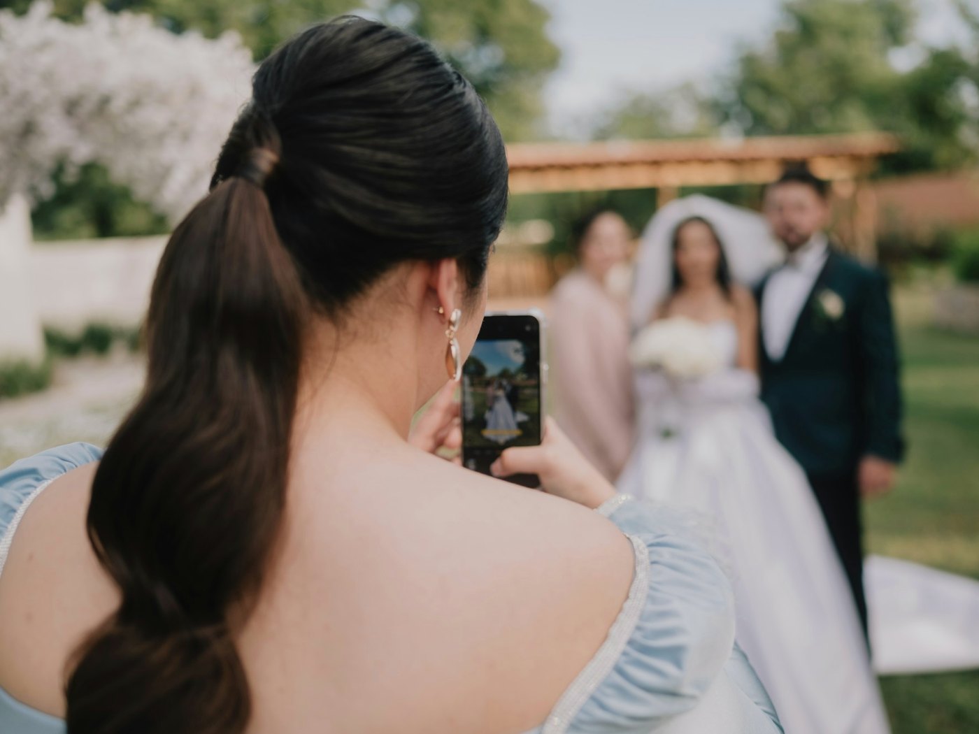 Gästevideos sammeln Hochzeitsgast filmt das Brautpaar mit dem Smartphone