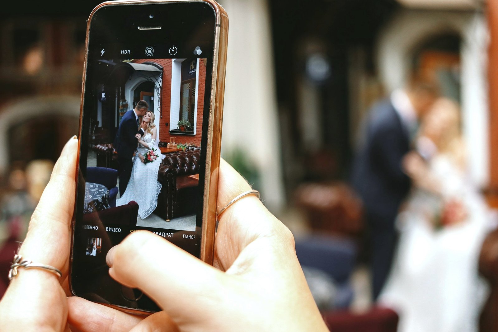 Gast fotografiert das Brautpaar Gast fotografiert das Brautpaar mit dem Smartphone in der Hochzeitslocation
